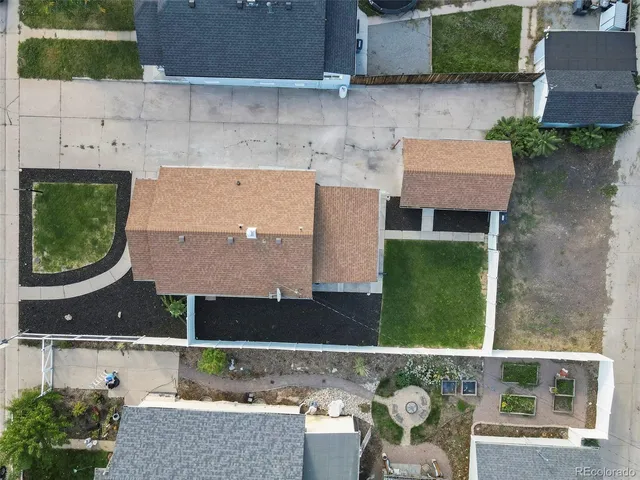 an aerial view of a house with garden space and a patio