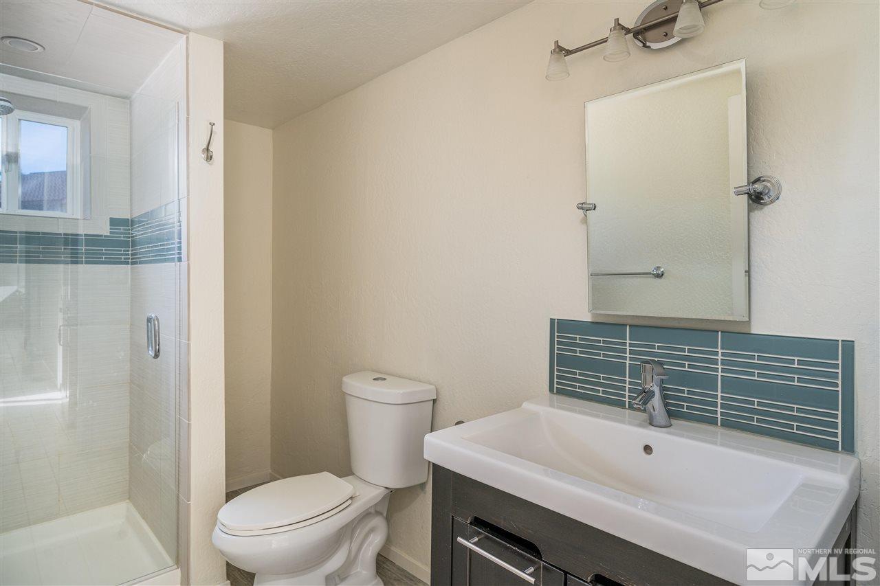 3975 Lamay Lane Reno, NV 89511 - Photo 15 of 28 a bathroom with a sink a toilet a mirror and shower