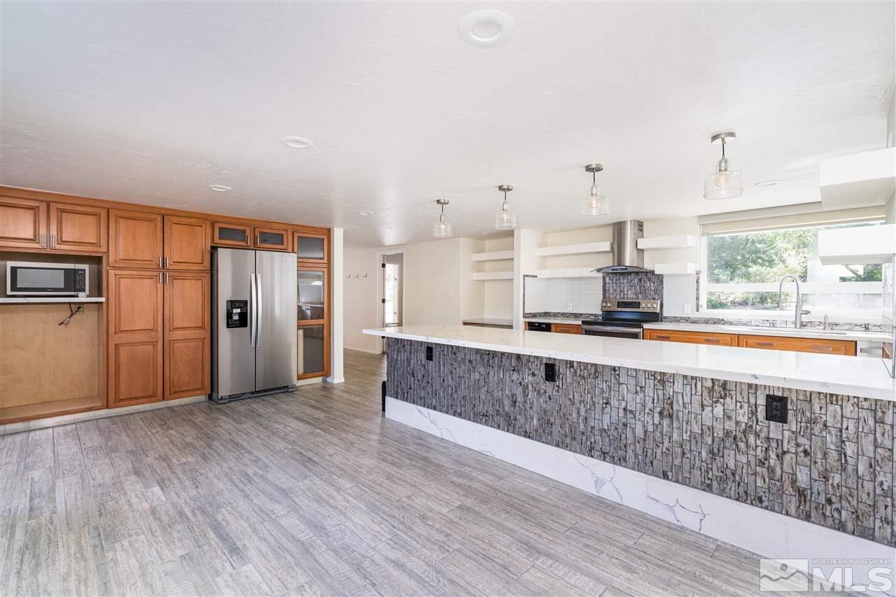3975 Lamay Lane Reno, NV 89511 - Photo 8 of 28 a large kitchen with stainless steel appliances granite countertop a large counter top and a wooden floors