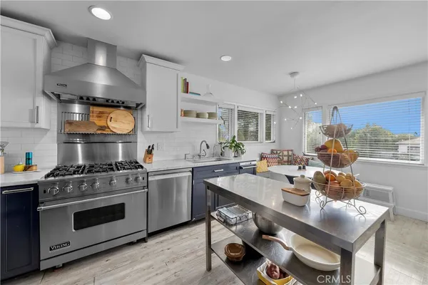 a kitchen with a stove cabinets and wooden floor