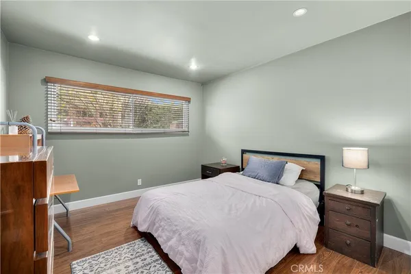 a bedroom with a bed and a lamp on dresser