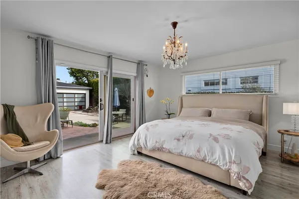 a spacious bedroom with a bed and a chandelier