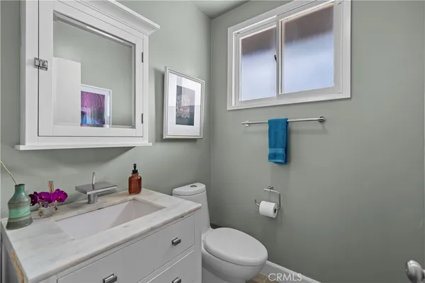 a bathroom with a toilet sink vanity and mirror
