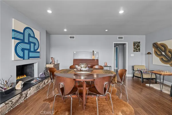 a view of a dining room with furniture wooden floor and a fireplace