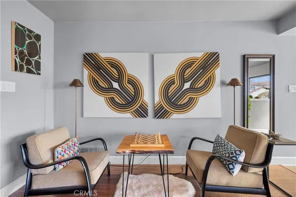 a balcony with chairs and paintings on wall