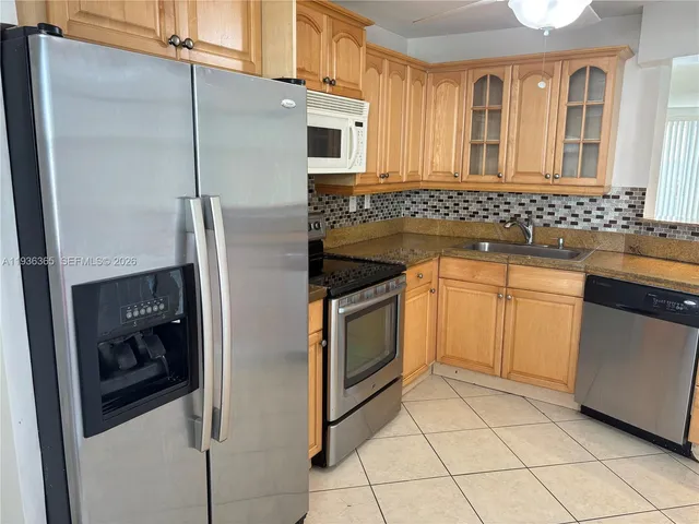 a kitchen with stainless steel appliances granite countertop a refrigerator and a sink