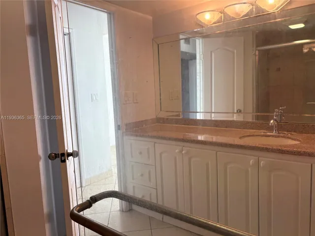 a bathroom with a granite countertop sink and a mirror