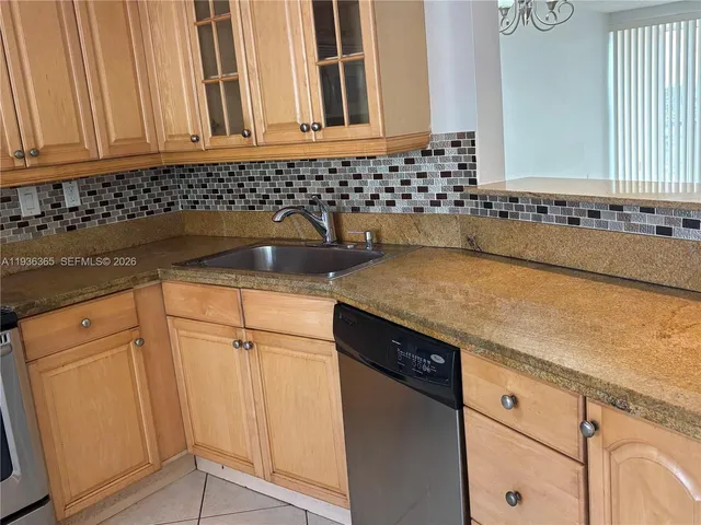 a kitchen with granite countertop a sink and a stove