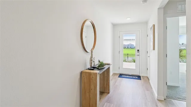 a view of a room with wooden floor mirror and windows