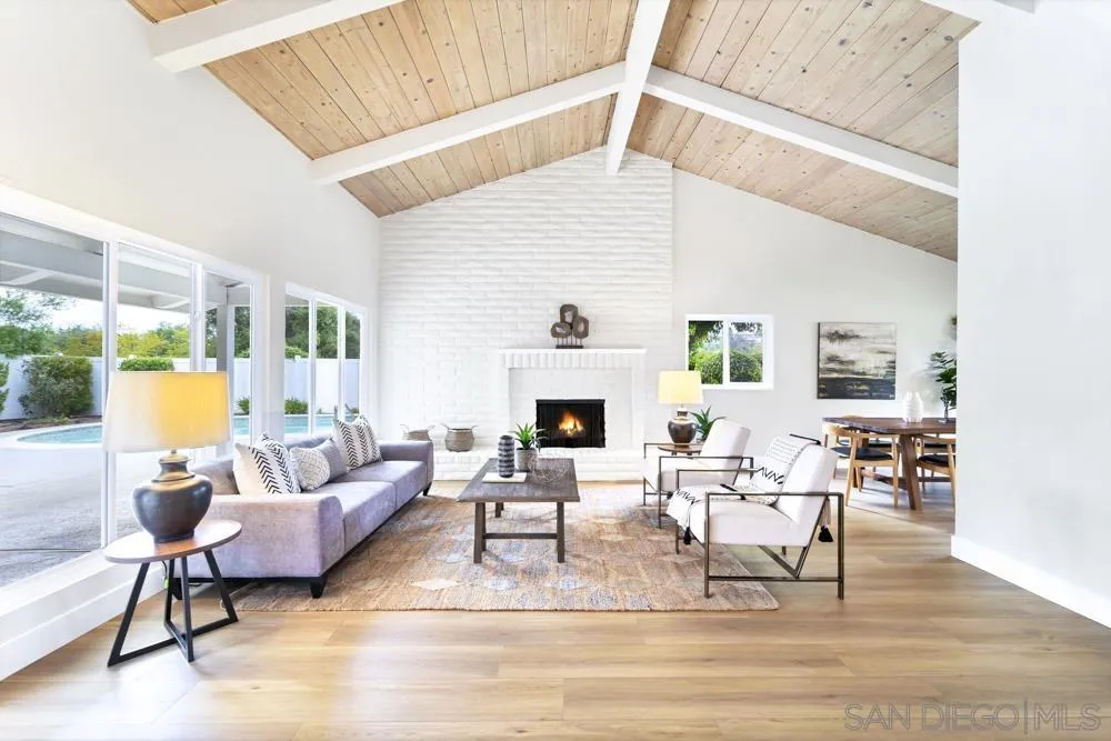 a living room with couches chairs and a fireplace with wooden floor