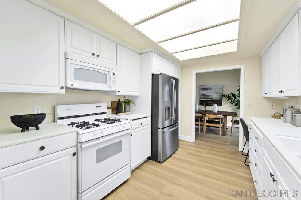 3563 Oak Cliff Drive Fallbrook, CA 92028 - Photo 15 of 43 a kitchen with white cabinets and stainless steel appliances