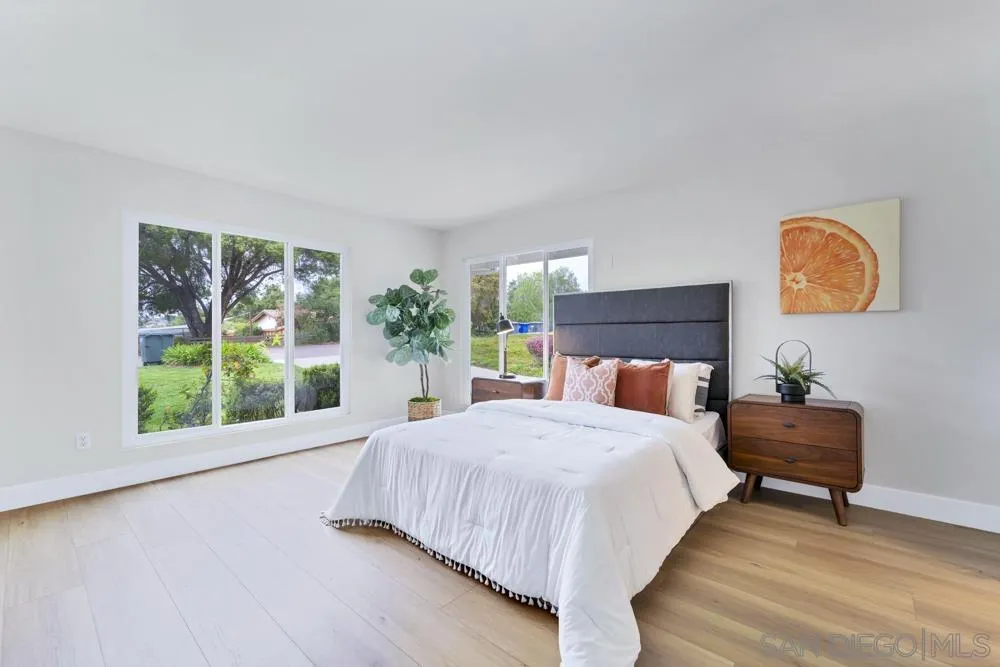 3563 Oak Cliff Drive Fallbrook, CA 92028 - Photo 21 of 43 a bedroom with a bed lamp and a large window
