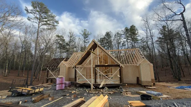 a wooden house with tall trees in front of it