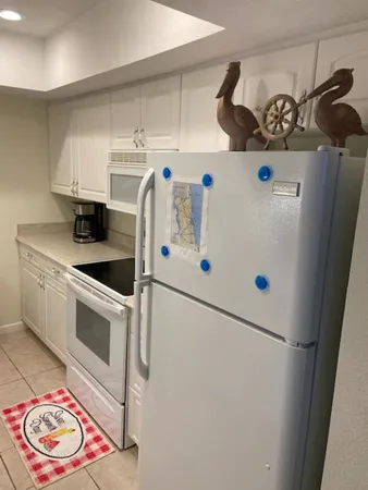a kitchen with stainless steel appliances a refrigerator sink and white cabinets