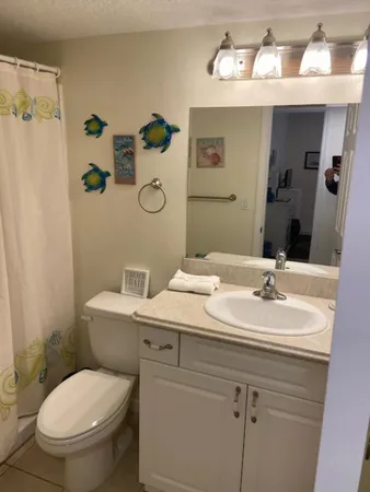 a bathroom with a toilet sink and mirror