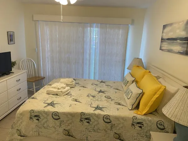 a bedroom with a bed and teddy bear on the bed