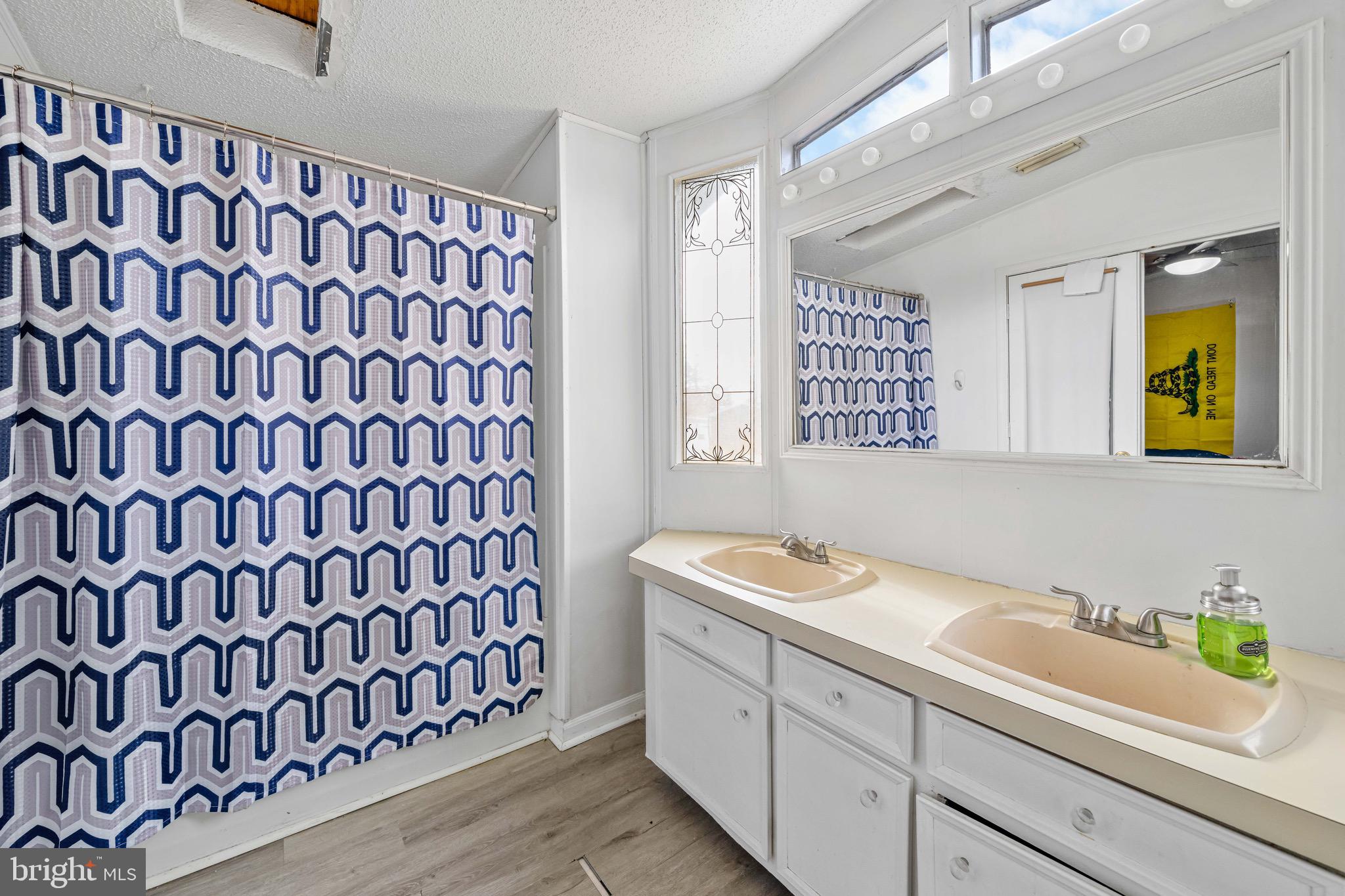 57 Gypsum Drive, Unit 195 Newark, DE 19713 - Photo 11 of 19 a bathroom with a sink a vanity and a shower