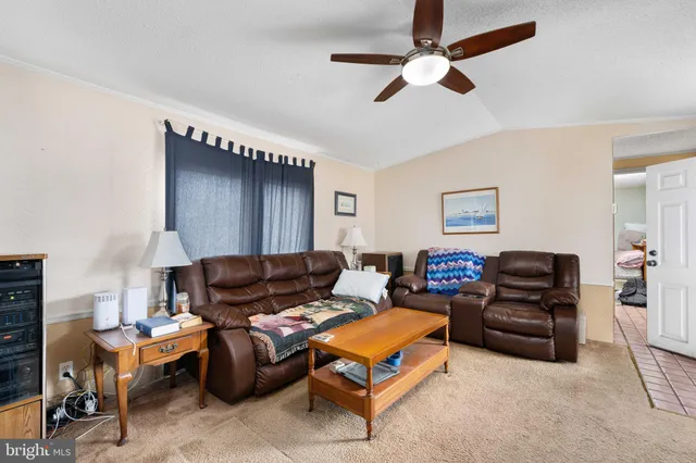 a living room with furniture a ceiling fan and a rug