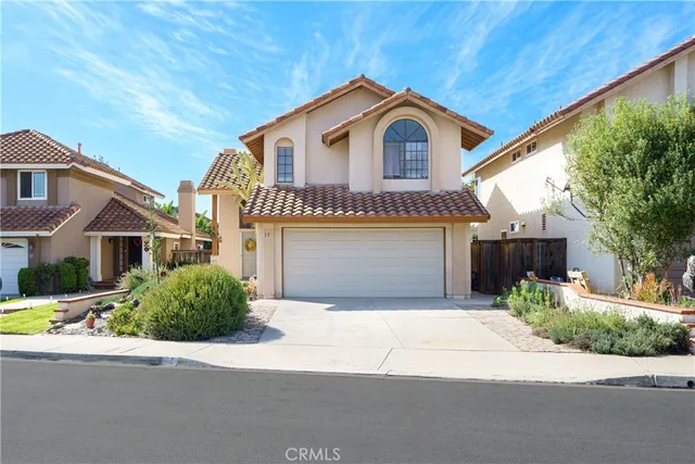 a front view of a house with a garden and garage