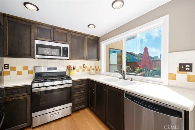 a kitchen with stainless steel appliances a stove sink and microwave