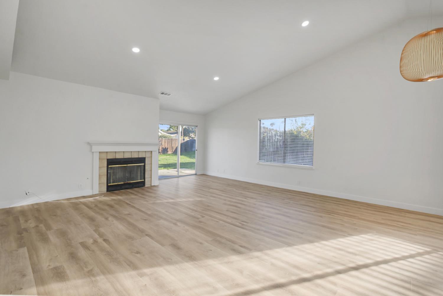 1128 Raymond Drive Modesto, CA 95351 - Photo 14 of 32 a view of an empty room with a fireplace and a window