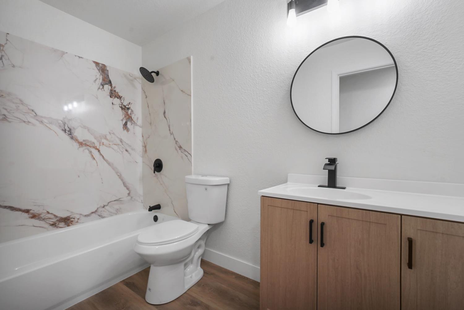 1128 Raymond Drive Modesto, CA 95351 - Photo 17 of 32 a bathroom with a toilet sink vanity tub and mirror
