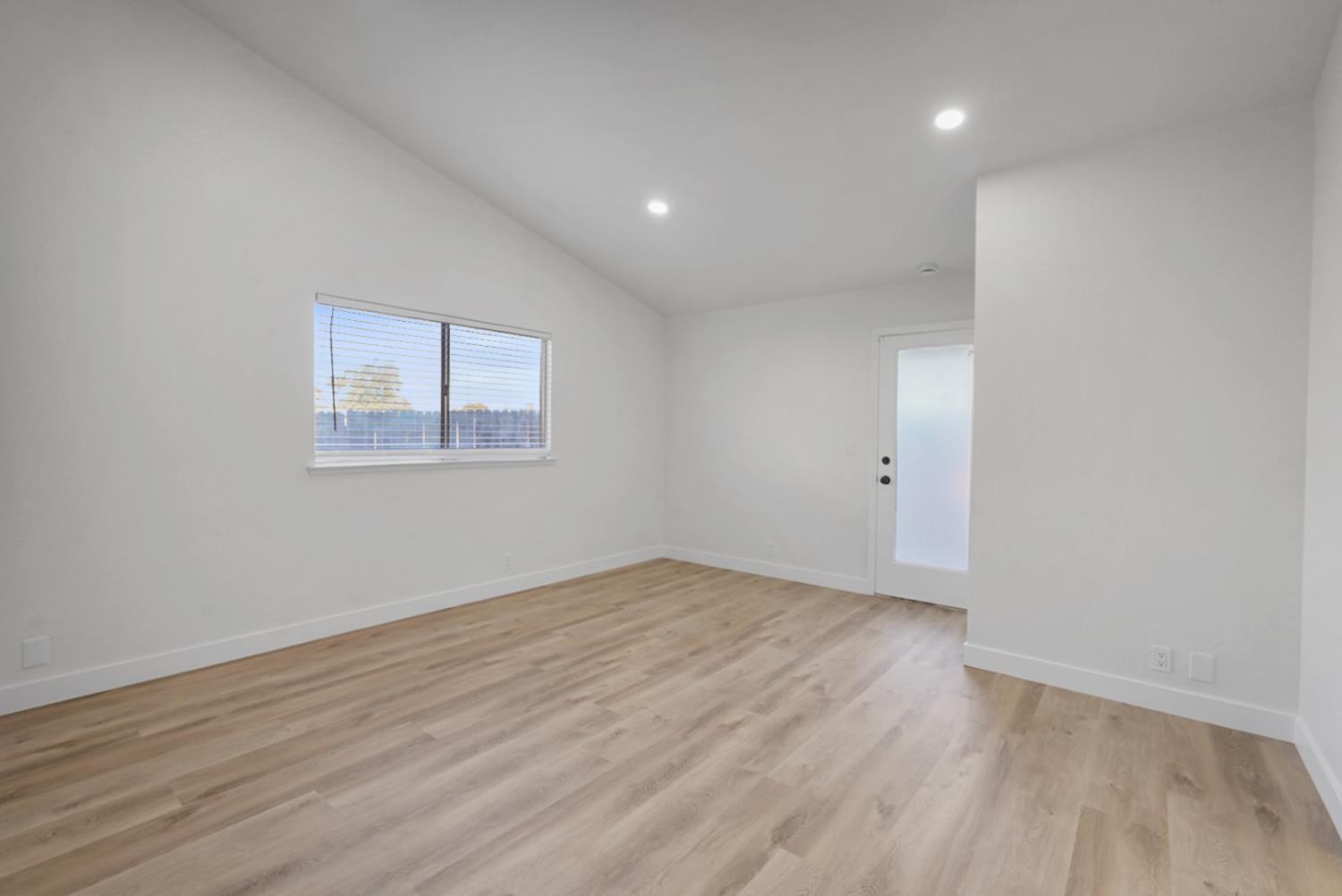 1128 Raymond Drive Modesto, CA 95351 - Photo 19 of 32 an empty room with wooden floor and windows