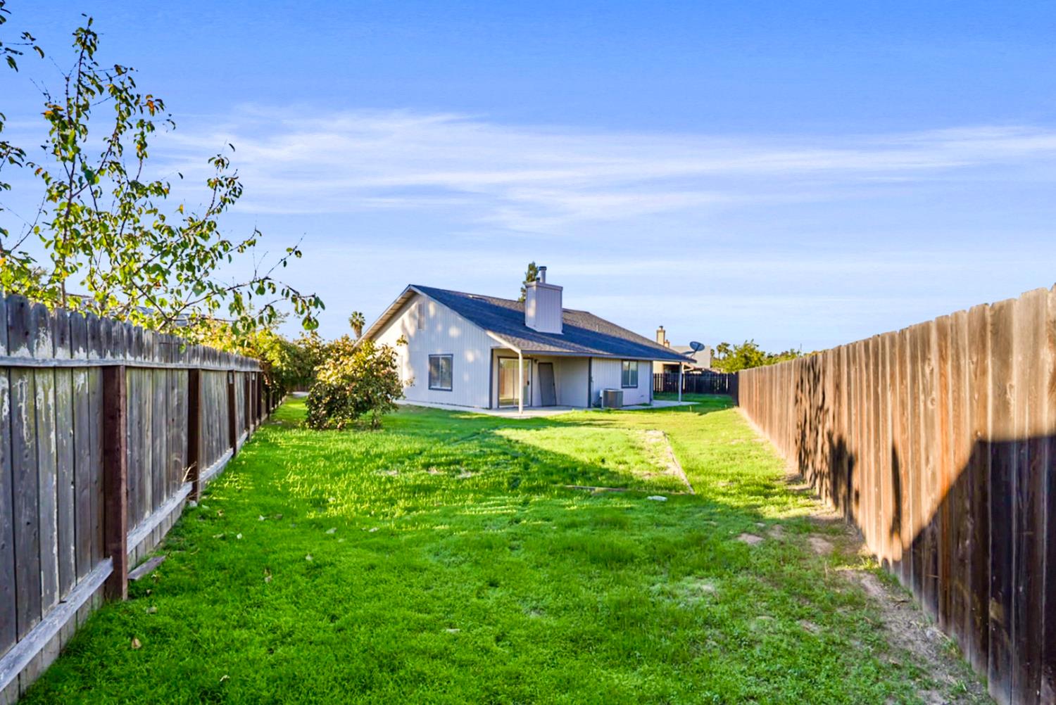 1128 Raymond Drive Modesto, CA 95351 - Photo 25 of 32 a yellow and red house with a big yard and large trees