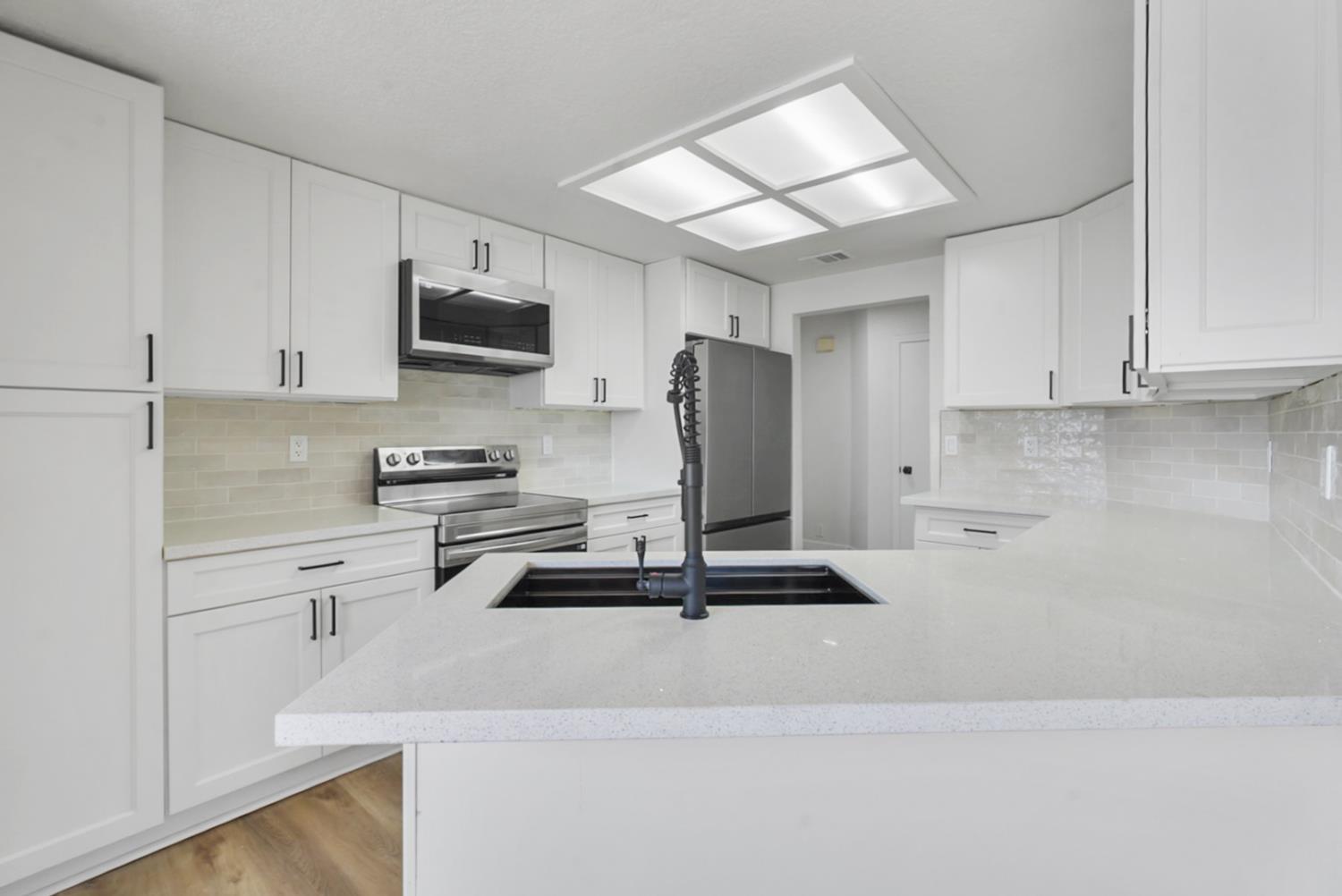 1128 Raymond Drive Modesto, CA 95351 - Photo 10 of 32 a kitchen with stainless steel appliances white cabinets and a sink