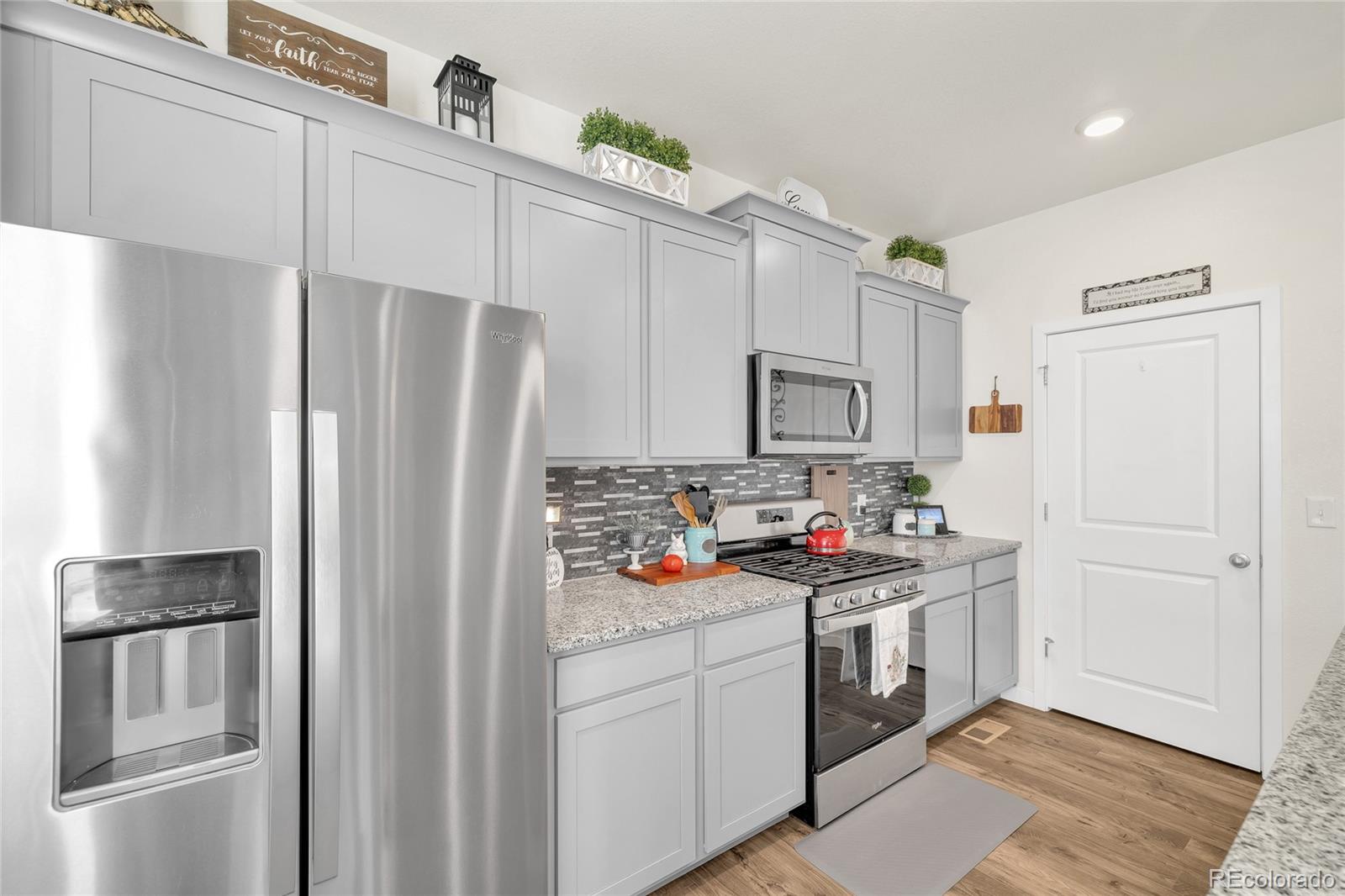 45824 Silverdrop Avenue Bennett, CO 80102 - Photo 14 of 49 a kitchen with stainless steel appliances a refrigerator stove and sink