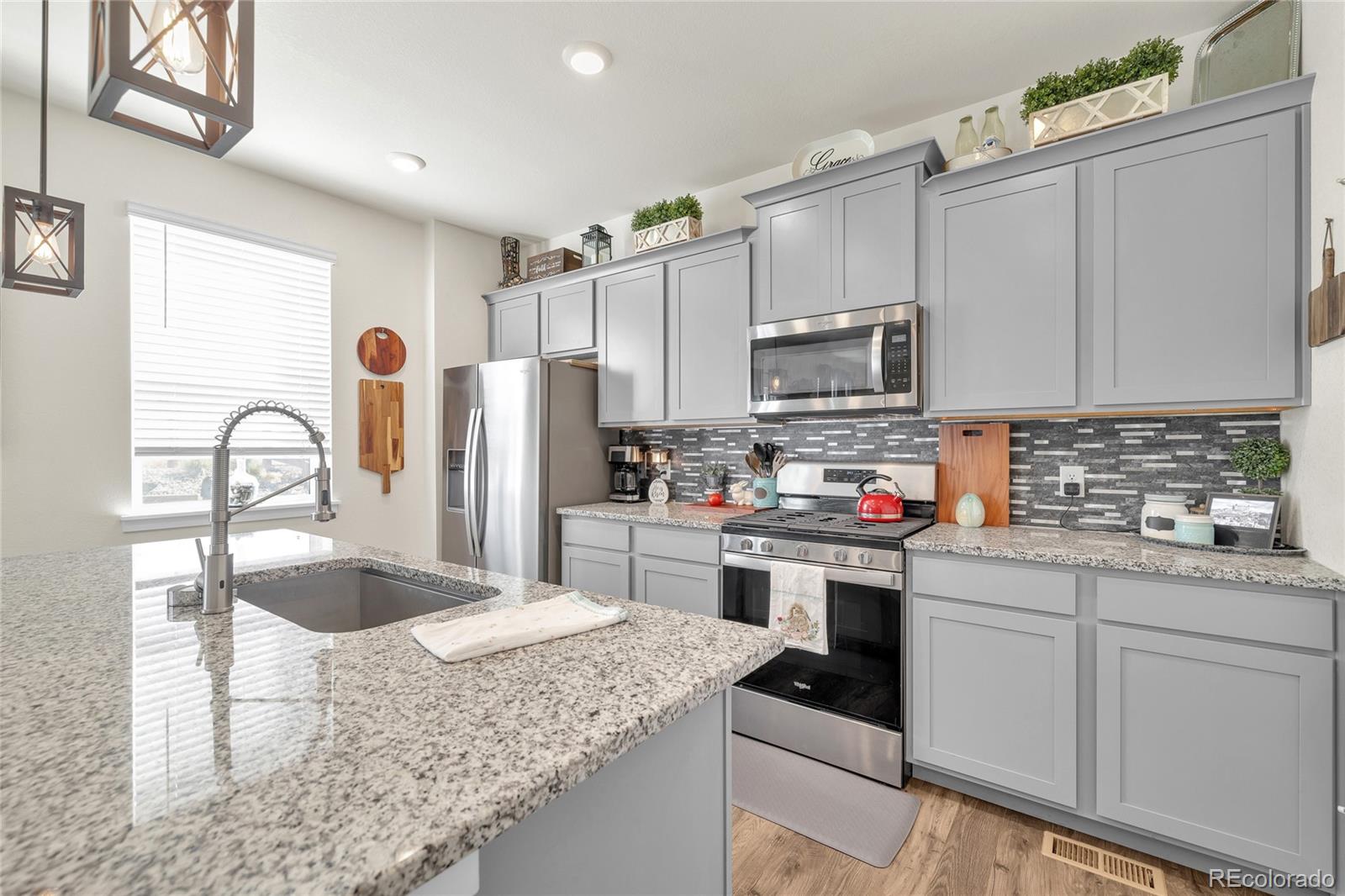 45824 Silverdrop Avenue Bennett, CO 80102 - Photo 10 of 49 a kitchen with stainless steel appliances granite countertop a sink stove and refrigerator