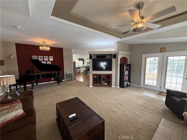 a living room with furniture piano and a chandelier