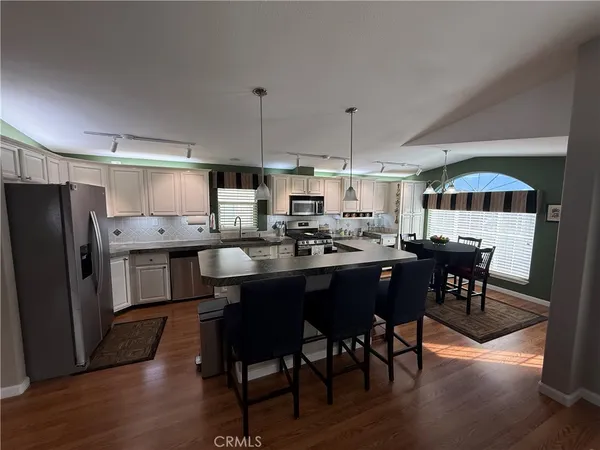 a kitchen with stainless steel appliances granite countertop a stove a microwave and a sink