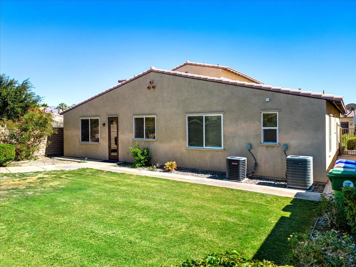 82732 Castleton Drive Indio, CA 92203 - Photo 31 of 45 a backyard of a house with table and chairs and potted plants