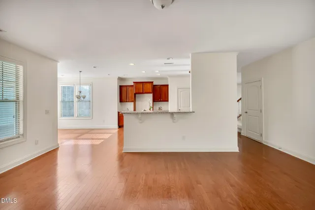 a view of a living room with kitchen and wooden floor