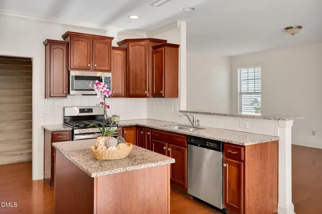 a kitchen with stainless steel appliances granite countertop a sink stove and cabinets