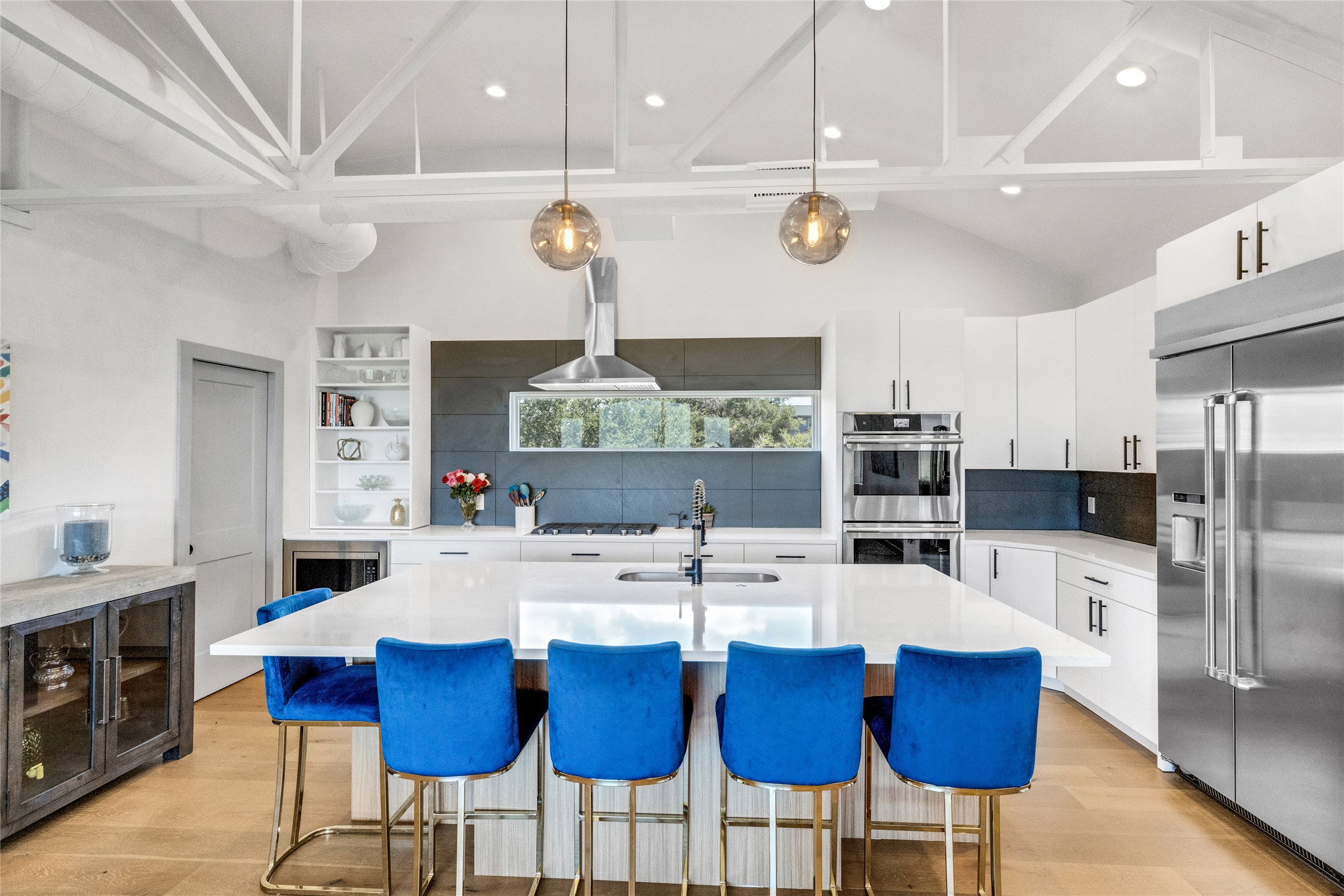 4227 Eck Lane Austin, TX 78734 - Photo 1 of 30 Kitchen with a breakfast bar, white cabinets, stainless steel appliances, decorative light fixtures, and lofted ceiling
