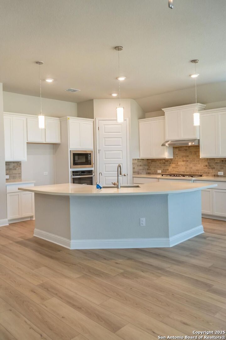 5209 Pinder Way Marion, TX 78124 - Photo 3 of 8 a kitchen with stainless steel appliances granite countertop a stove a sink and a refrigerator