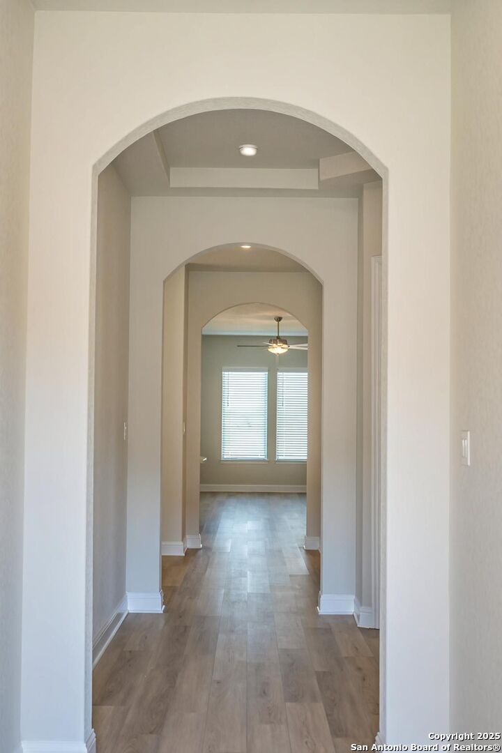 5209 Pinder Way Marion, TX 78124 - Photo 8 of 8 a view of a hallway with wooden floor and a living room