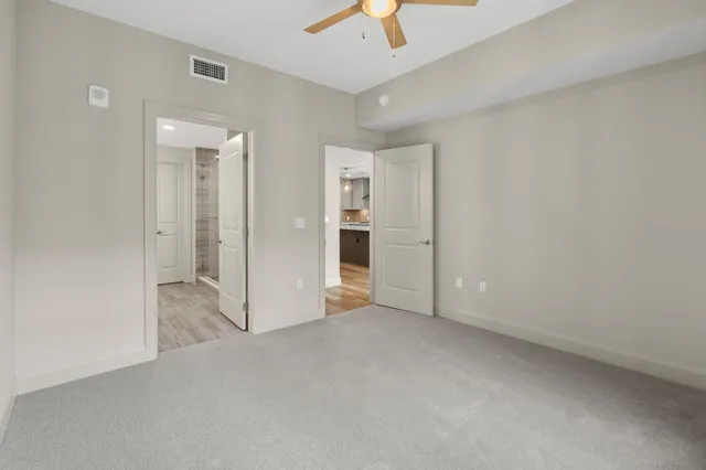 an empty room with closet and a chandelier fan