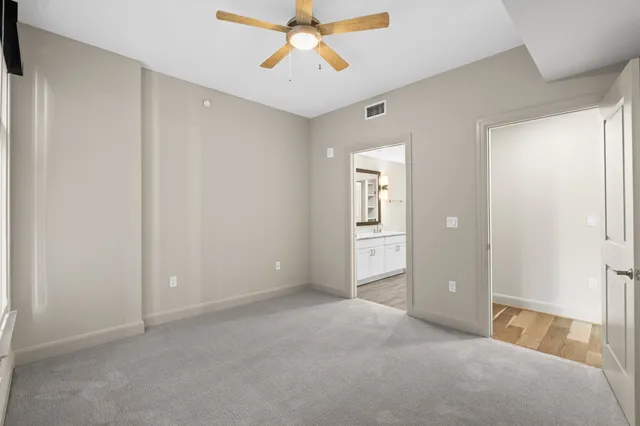 an empty room with windows and fan