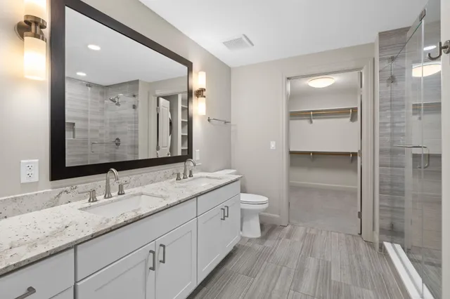 a bathroom with a granite countertop sink toilet and shower