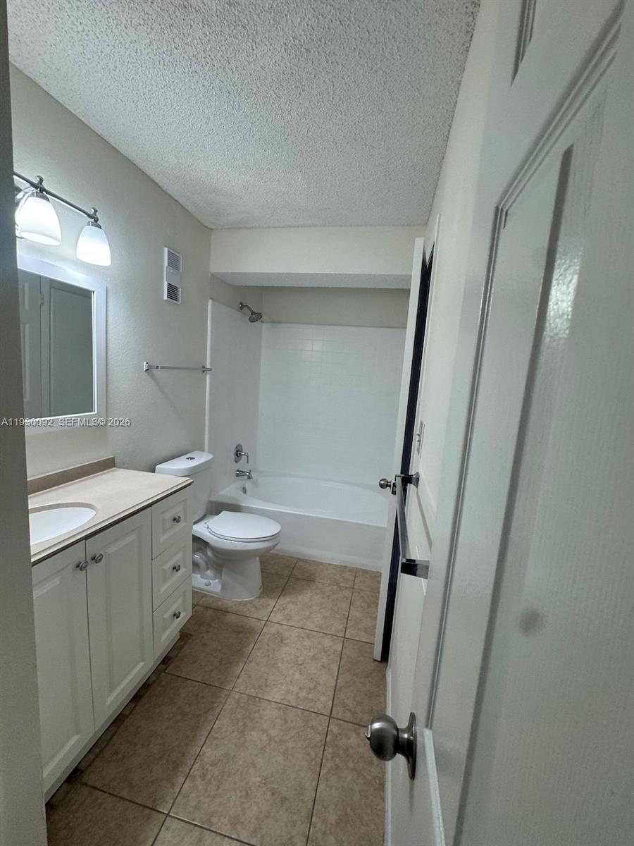 10501 Southwest 155th Court, Unit 1121 Miami, FL 33196 - Photo 22 of 28 a bathroom with a granite countertop sink toilet mirror and a bathtub