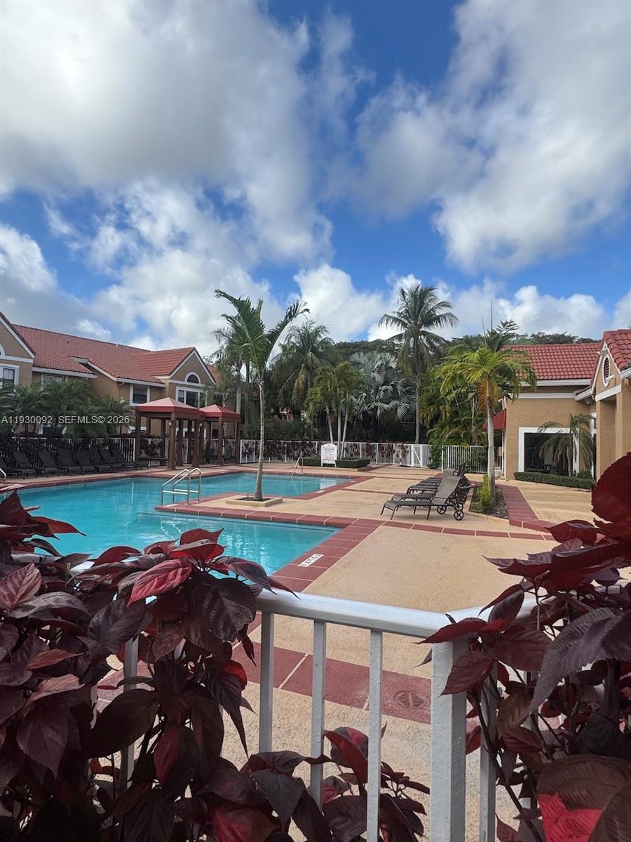 10501 Southwest 155th Court, Unit 1121 Miami, FL 33196 - Photo 27 of 28 a view of a swimming pool with a patio and a yard