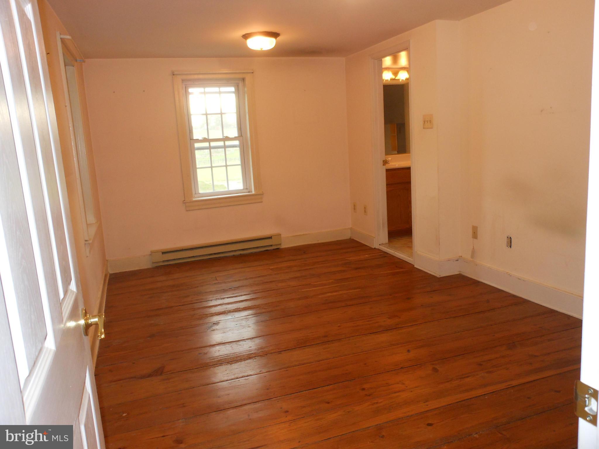 21715 Middletown Road Freeland, MD 21053 - Photo 2 of 30 an empty room with wooden floor and windows with curtains