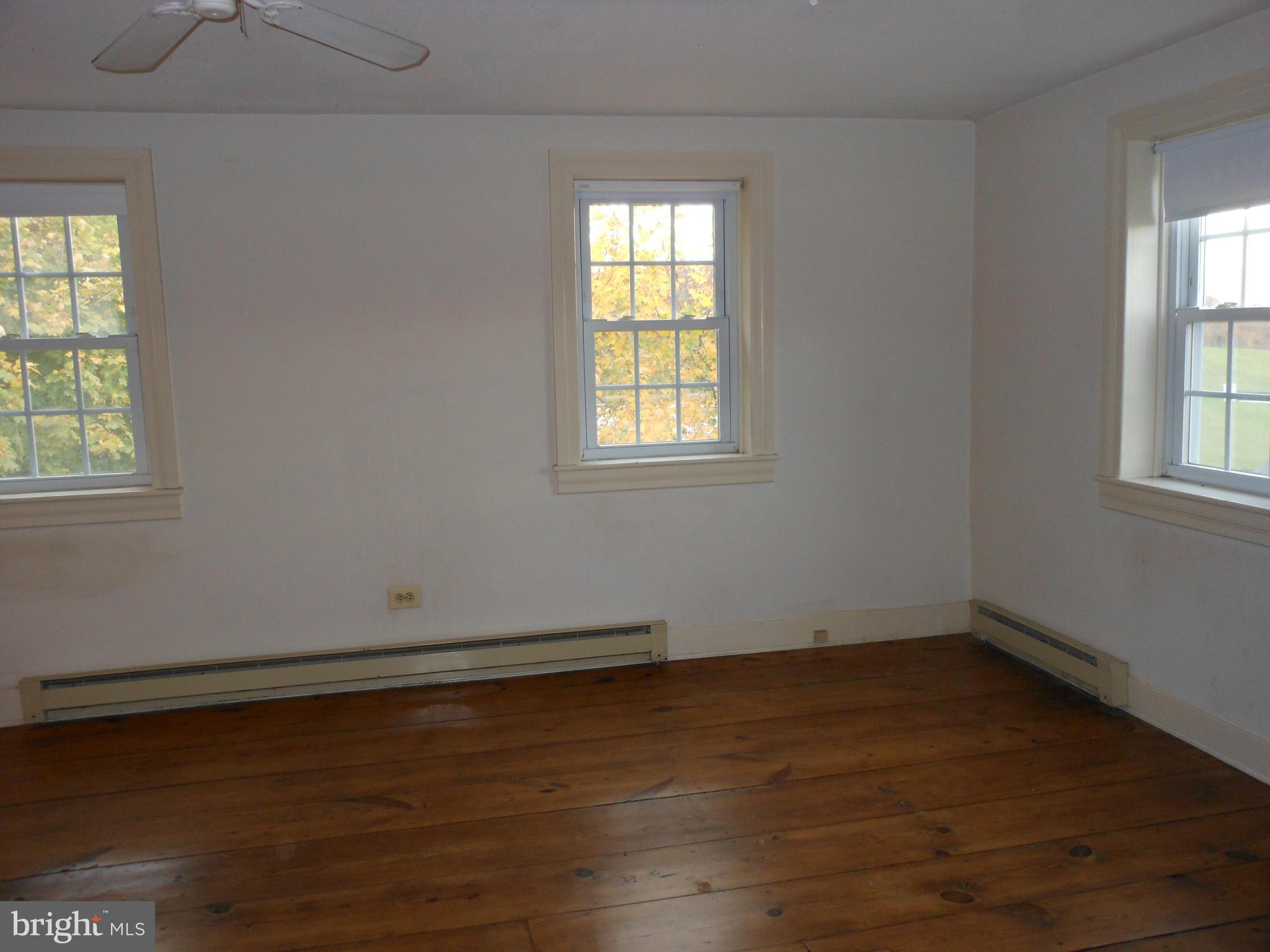 21715 Middletown Road Freeland, MD 21053 - Photo 9 of 30 an empty room with wooden floor and windows