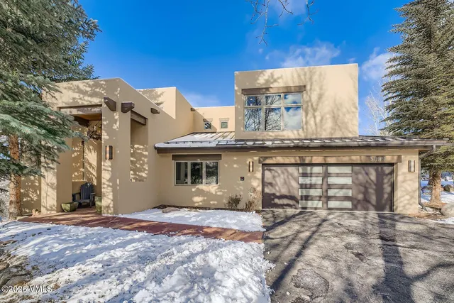 a view of a white house with a outdoor space and a wooden fence