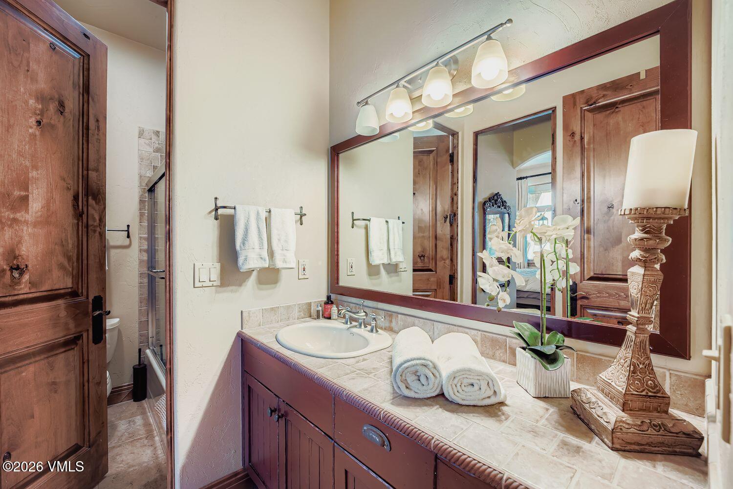 311 Foal Drive Edwards, CO 81632 - Photo 25 of 29 a bathroom with a granite countertop sink a mirror and shower