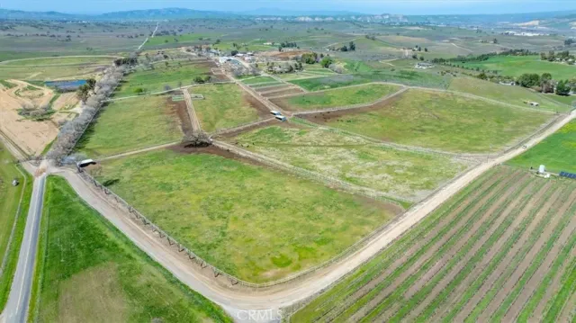 an aerial view of a house with a garden and lake view