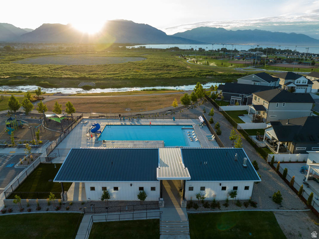 82 Provo River Road, Unit 251 Saratoga Springs, UT 84045 - Photo 29 of 32 Outdoor swimming pool with integrated tanning ledge, surrounded by a concrete deck and a contemporary white building featuring a dark metal roof